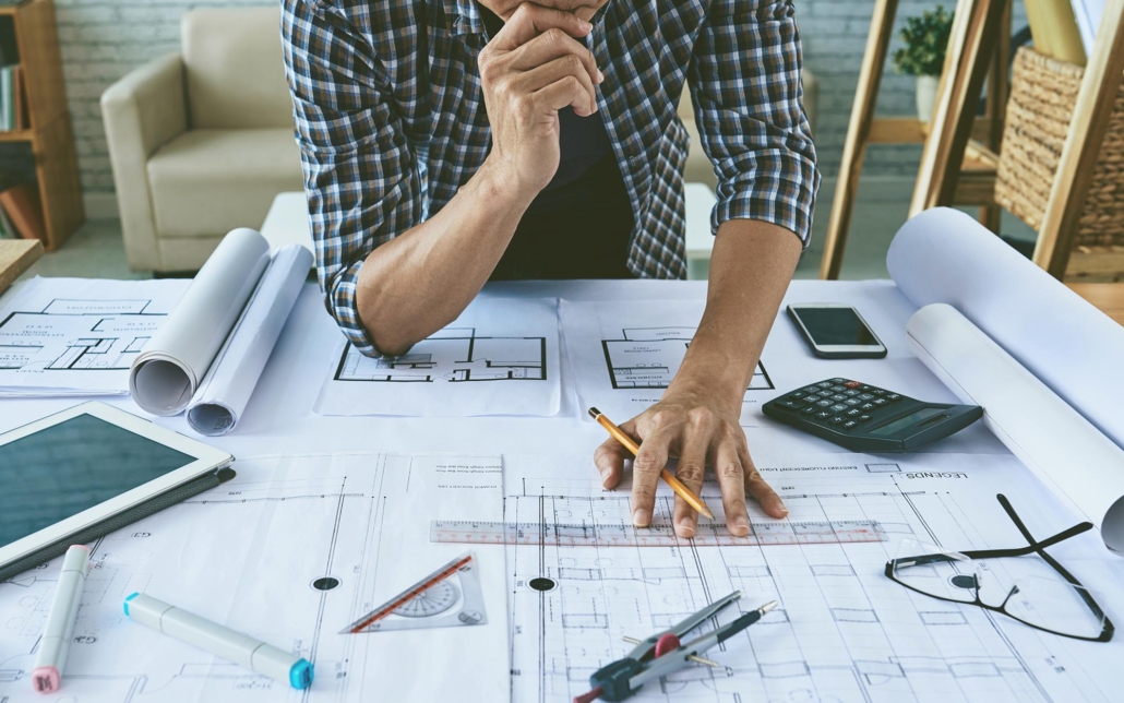 Image of an engineer reviewing blueprints for a commercial construction project.