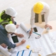 Team of engineers and architects working, planing, measuring layout of building blueprints in construction site. top view_