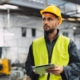 Front view of a construction worker holding a smart tablet