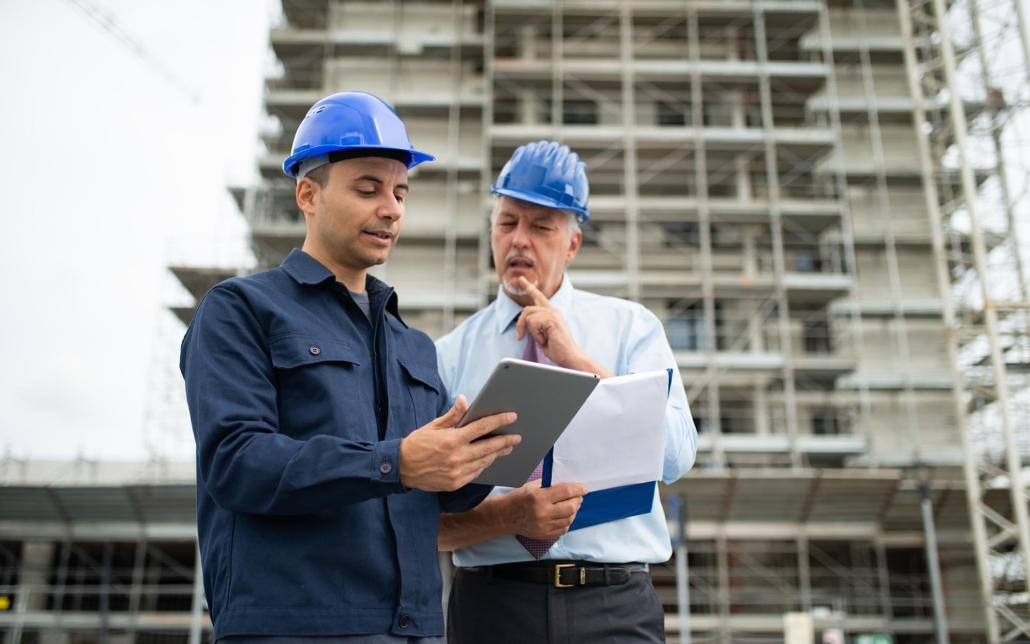 Two construction professionals looking at clipboard