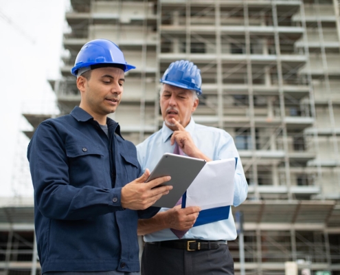 Two construction professionals looking at clipboard