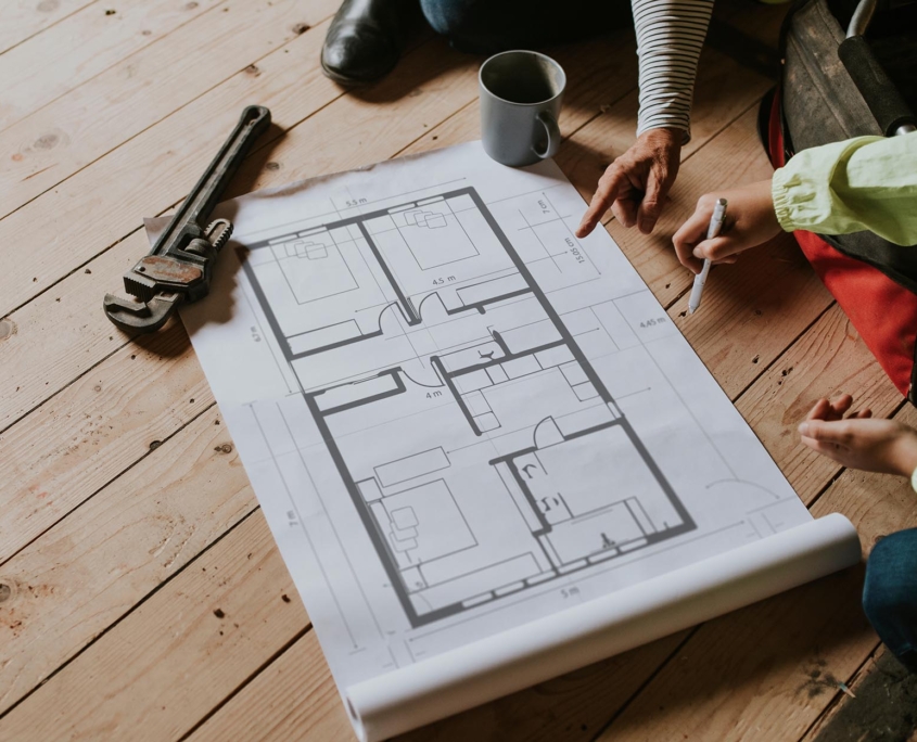 Two construction workers looking over blueprints